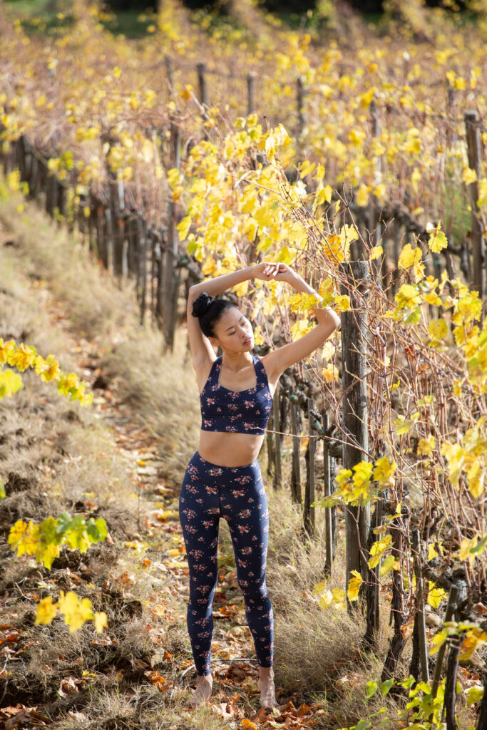 high end outdoor fashion editorial of model in printed activewear set in an autumn vineyard