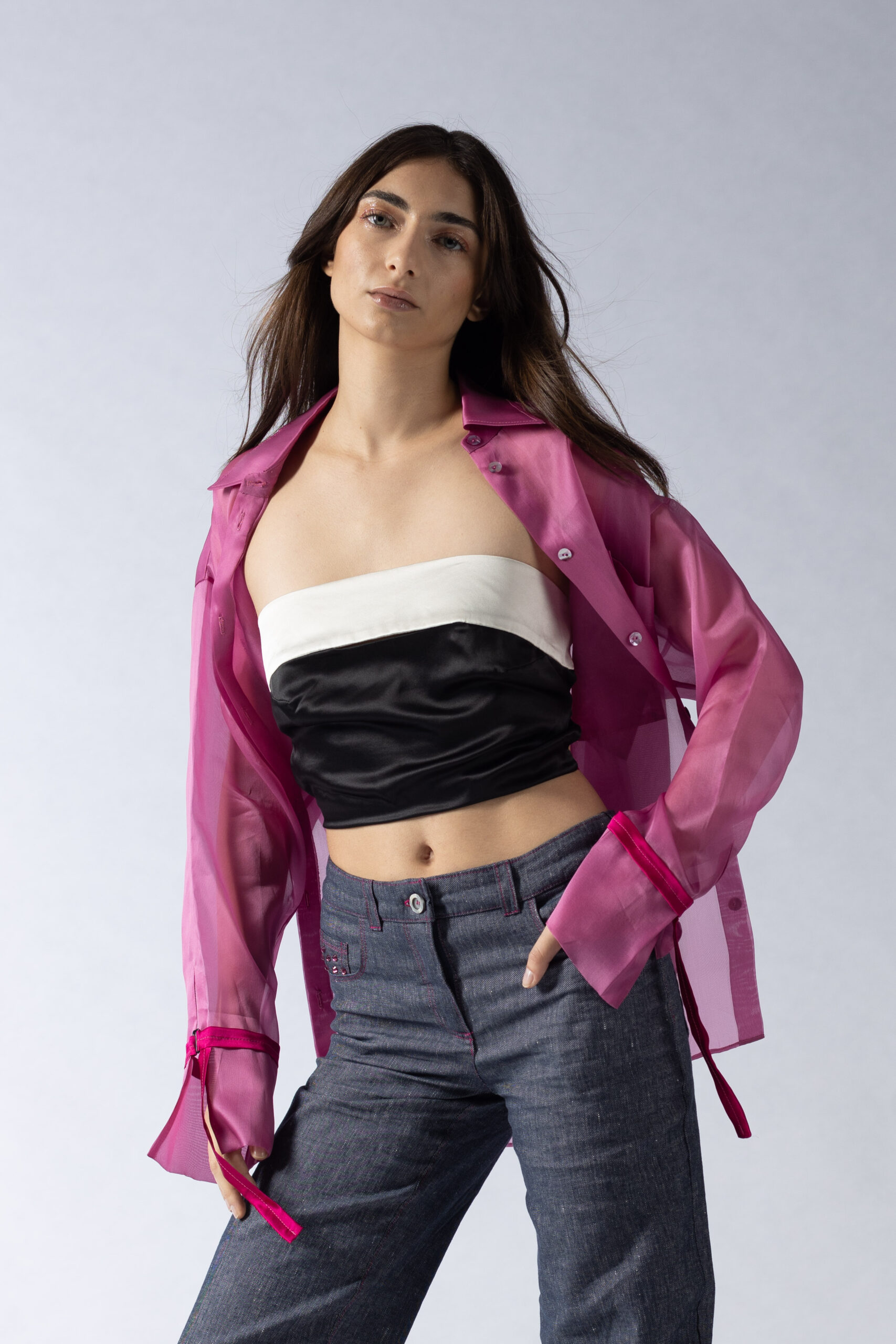 high end fashion studio editorial y2k style with model in jeans and pink overshirt