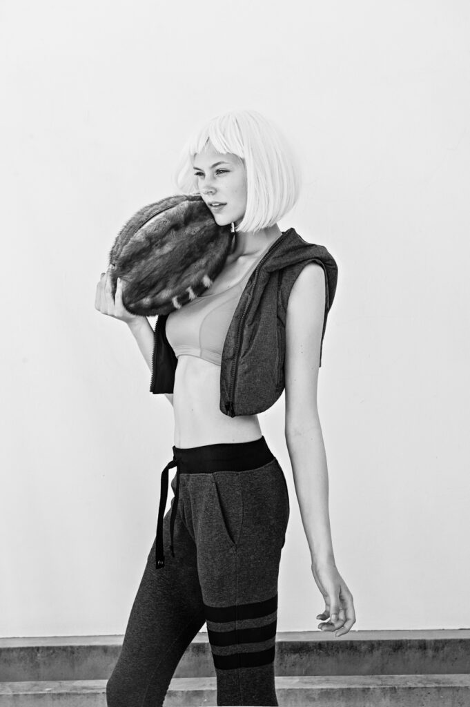 streetwear b&w editorial of model wearing fashion sportswear and holding a fur ball