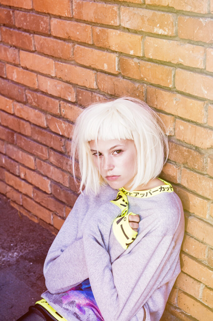 moody high end streetwear fashion editorial, model close up, brick wall